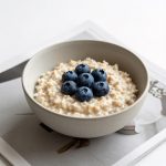 Minimalist Oatmeal Breakfast with Blueberries and Magazine Pages