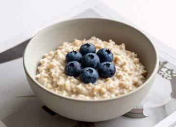 Minimalist Oatmeal Breakfast with Blueberries and Magazine Pages