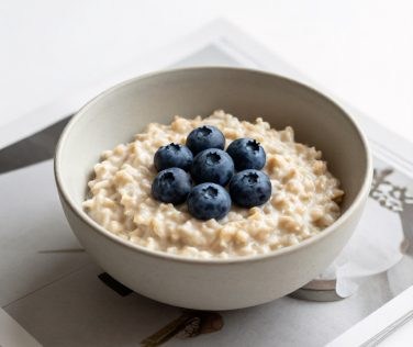 Minimalist Oatmeal Breakfast with Blueberries and Magazine Pages